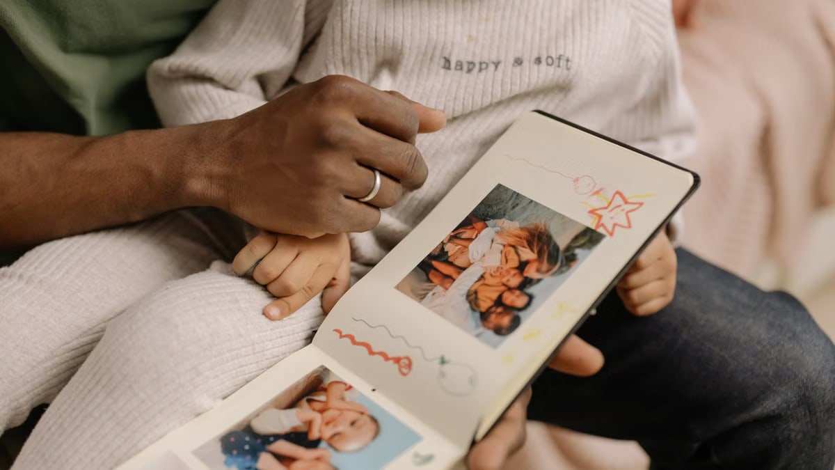 A father and child share a touching moment revisiting cherished family memories in a photo album.