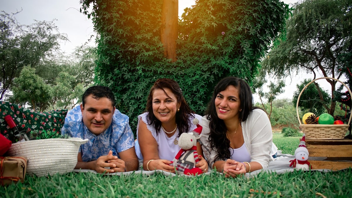 a group of people laying on top of a lush green field
